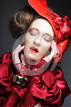 Young beautiful woman in a red lace suit and hat.