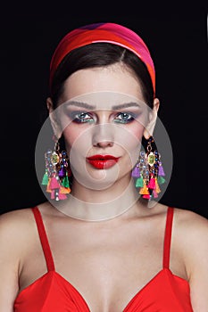 Young beautiful woman with red lips and fancy massive earrings