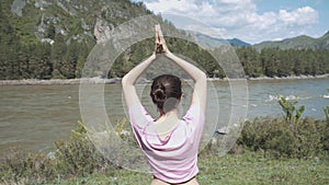 Young beautiful woman in red tank top practicing outdoors, doing Bending Tree posture, variation of Vrksasana, in park