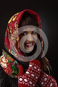 young beautiful woman in a red traditional Russian shawl on black background