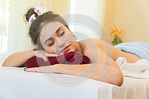 Young beautiful woman relaxation laying on massage spa bed in spa environment