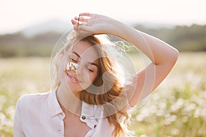 Young beautiful woman relaxing in chamomile field