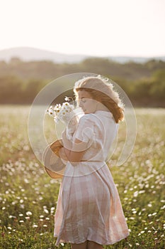 Young beautiful woman relaxing in chamomile field