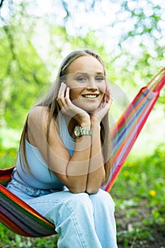 Young beautiful woman relaxing in hammock outdoors