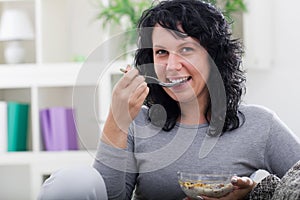 Young beautiful woman relaxing at home,eating cereals