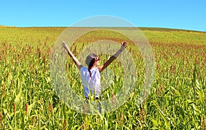 Young beautiful woman relaxing in the middle of a green cereals field during the last days of summer in the Pyrenees mountains