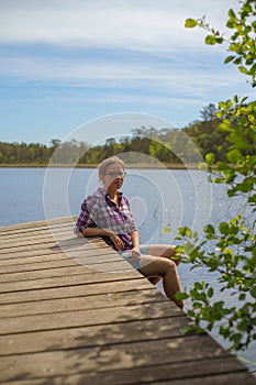 Young beautiful woman relaxing near scenic lake