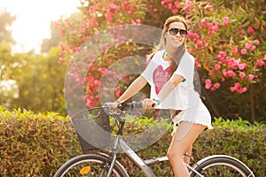 Young beautiful woman riding bicicle on summer photo