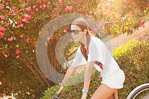 Young beautiful woman riding bicicle on summer photo