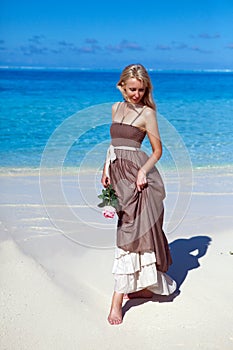 The young beautiful woman with a rose near the sea, tropics