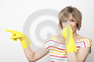 Young beautiful woman in rubber gloves holding her nose