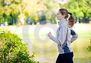 Young Beautiful Woman Running in the Autumn Park