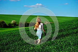 Young beautiful woman running on a green field