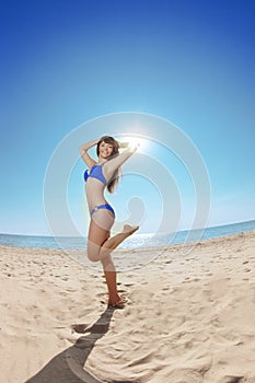 Young beautiful woman on the sand by the sea