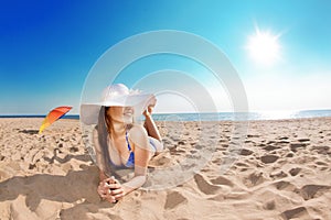 Young beautiful woman on the sand by the sea