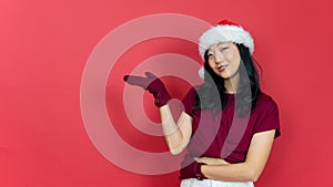 young beautiful woman with santa hat over red color background. Inviting to enter smiling natural with open hands. Concept of the