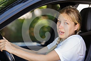 Young beautiful woman scared and stressed while driving car