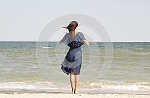Young beautiful woman at seaside in blue dress