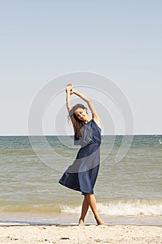 Young beautiful woman at seaside in blue dress