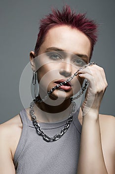 Young beautiful woman with short color hair and chain necklace