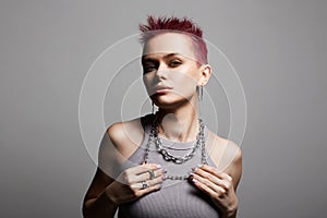 Young beautiful woman with short color hair and chain necklace