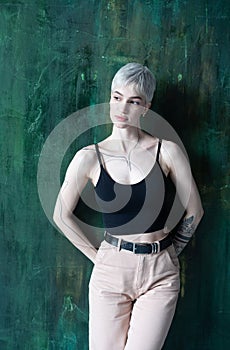 Young beautiful woman with short hair poses in the studio, stands