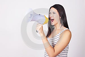 Young beautiful woman shouting through a megaphone