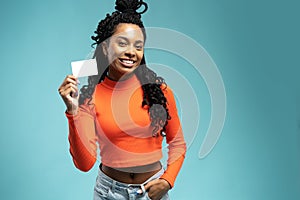 Young beautiful woman showing copy space on empty blank sign or gift card isolated on blue background