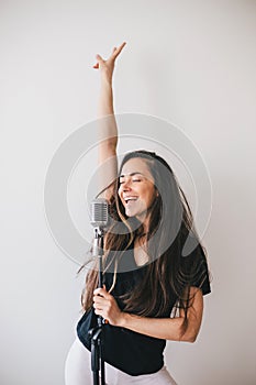 Young beautiful woman sing in vintage microphone.