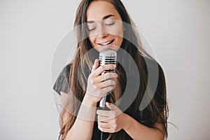 Young beautiful woman sing in vintage microphone.