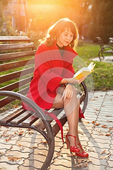 Young beautiful woman sitting on a bench in autumn Park