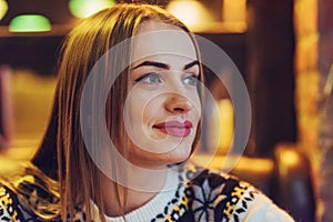 Young beautiful woman sitting in cafe, drinking coffee. Model looking up. Christmas, new year, Valentines day, winter holidays con