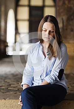 Young beautiful woman sitting miserable on the stairs