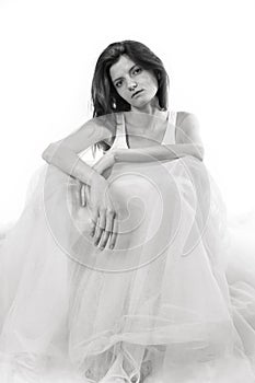 Young beautiful woman sitting in tulle dress monochrome portrait