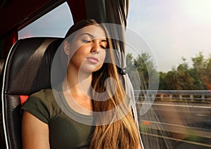 Young beautiful woman sleeping sitting in the bus. Bus passenger traveling sitting in a seat and sleeping