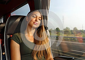 Young beautiful woman sleeping sitting in the bus. Bus passenger traveling sitting in a seat and sleeping