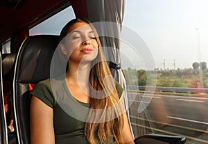 Young beautiful woman sleeping sitting in the bus. Bus passenger traveling sitting in a seat and sleeping