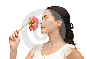 Young and beautiful woman smelling flower