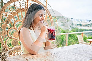 Young beautiful woman smiling happy drinking cocktail