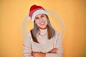 Young beautiful woman smilling happy wearing winter sweater and a santa claus hat at christmas