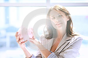 Young beautiful woman standing with piggy bank money box, isolated on white background