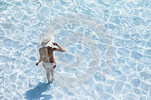 Young beautiful woman standing in the sea and enjoying summer. Summer fun, vacation, holidays, enjoy life concept