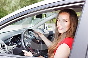 Young beautiful woman steering wheel driving a car