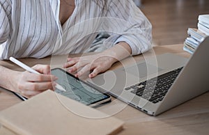 Young beautiful woman student with digital tablet and laptop studying working at home at the table