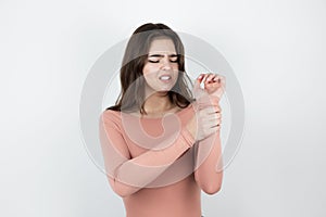 Young beautiful woman suffering from pain in her wrist looking helpless on isolated white background, healthcare concept