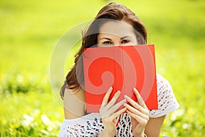 Young beautiful woman in summer park with a book