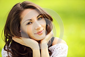 Young beautiful woman in summer park smiling