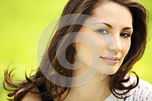 Young beautiful woman in summer park smiling