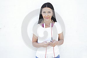 Young beautiful woman summer portrait with mobile phone and headphones