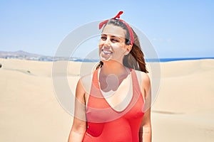 Young beautiful woman sunbathing wearing summer swinsuit at maspalomas dunes bech